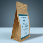 Barista-It Brown paper coffee bag with a label on a teal background.
