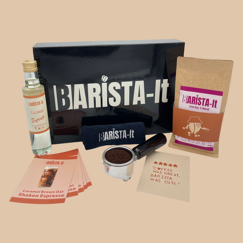Collection of Caramel Barista-it coffee products including a black box, Syrup bottle and recipe cards.